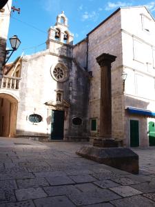 ein Gebäude mit einer Uhr auf der Seite in der Unterkunft Leut Apartment in Korčula