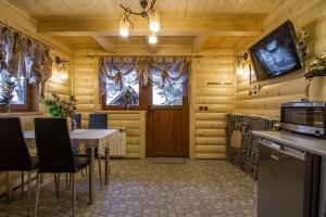 a dining room with a table and a tv on the wall at Domki Mroz in Zakopane