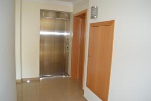 einen leeren Flur mit Aufzug und Tür in der Unterkunft Arenilha Guest House in Vila Real de Santo António