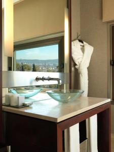 a bathroom with two glass sinks and a mirror at Hotel Miramar Barcelona GL in Barcelona