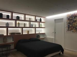 a bedroom with a black bed and some shelves at Appartements Haussman Lafayettes in Paris