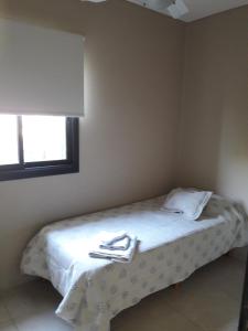 ein Bett in einem Zimmer mit zwei Servietten darauf in der Unterkunft Aires Sunchales in Sunchales