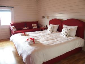 a large bed with a red headboard with two presents on it at Ktima Noosfera Wellness & Retreat Center in Nees Vrisoules