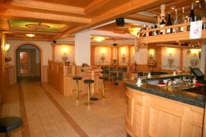 a bar in a restaurant with bar stools at Dolomiti Hotel Olimpia in Andalo
