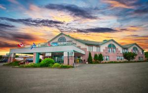 un edificio de hotel con una puesta de sol en el fondo en Travelodge by Wyndham Victoriaville, en Victoriaville