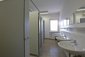 林茨Montagehotel Living@Linz的浴室设有4个水槽和一排镜子