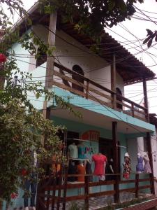 una tienda frente a un edificio con gente de pie fuera en Apartamento de Marconi, en Morro de São Paulo