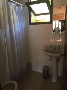 baño con lavabo y cortina de ducha en Cabanas Cucu, en Piriápolis