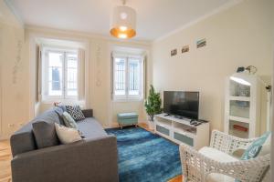 a living room with a couch and a tv at Mouraria 2 Bedroom Apartment in Lisbon