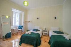 1 Schlafzimmer mit 2 Betten und grüner Bettwäsche in der Unterkunft Mouraria 2 Bedroom Apartment in Lissabon