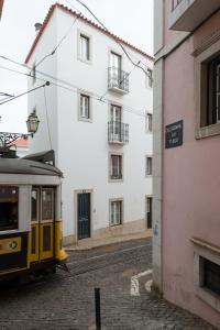 un tram su una strada accanto a un edificio di Almamater Lisbon Apartments a Lisbona