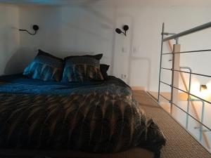 a bedroom with a bed with a brown comforter and pillows at L'Annexe Ginkg'Home in Saint-Max