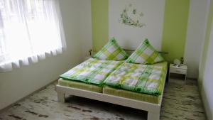 a small bedroom with a bed with green and yellow sheets at Ferienwohnung "am Zittauer Gebirge" in Olbersdorf