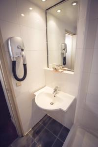 a bathroom with a sink and a mirror and a phone at Timhotel Paris Gare de Lyon in Paris