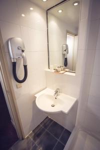 La salle de bains est pourvue d'un lavabo, d'un miroir et d'un téléphone. dans l'établissement Timhotel Paris Gare de Lyon, à Paris