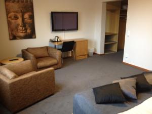 a living room with a couch and a chair and a television at Kumla Hotel in Kumla