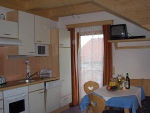 a kitchen with a table with a blue table cloth at Appartement Stocker in Aich