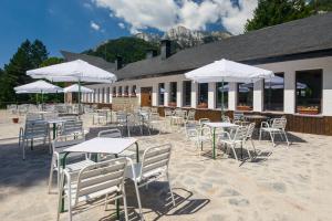 a group of tables and chairs with white umbrellas at Camping Selva de Oza in Hecho