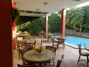 a patio with tables and chairs next to a pool at Hotel Eldorado Inn in Feira de Santana