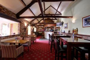 ein Restaurant mit Tischen und Stühlen und eine Bar in der Unterkunft Manor Court Hotel in Bridlington