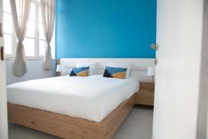 - une chambre dotée d'un lit avec un mur bleu dans l'établissement SweetHome26 Luxury Apt Sea View 50 meters from the beach free parking, à Tel Aviv