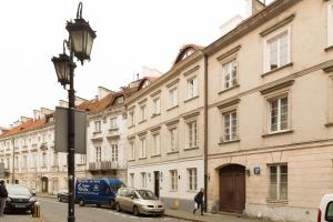 um grupo de edifícios numa rua com carros estacionados em Amazing Old Town Chill Out Apt em Varsóvia