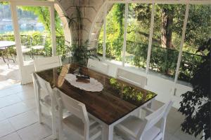 a dining room with a table and chairs and windows at Villa Korčula in Korčula