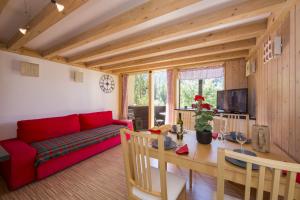 a living room with a red couch and a table at Résidence Grand Roc - Campanules 112 - Happy Rentals in Chamonix