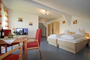 a hotel room with two beds and a desk and a table at Ferienhof Rieger in Rotthalmünster