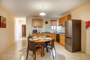 a kitchen with a table with chairs and a refrigerator at Victoria Penthouse in Victoria