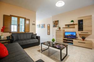 ein Wohnzimmer mit einem Sofa und einem TV in der Unterkunft Victoria Penthouse in Victoria