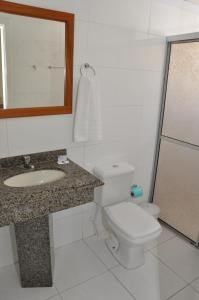 ein Badezimmer mit einem WC, einem Waschbecken und einem Spiegel in der Unterkunft Klein Ville Esteio Centro in Esteio
