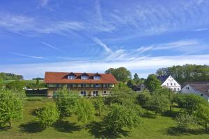 ein Haus mit rotem Dach auf einem grünen Feld in der Unterkunft Ferienhof Rieger in Rotthalmünster