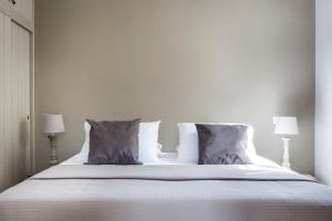 a white bed with two pillows and two lamps at Myrtos View Apartments in Anomeriá