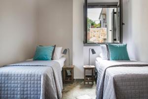 two beds in a room with blue pillows at Myrtos View Apartments in Anomeriá