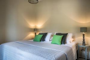 a bedroom with a bed with green and white pillows at Myrtos View Apartments in Anomeriá