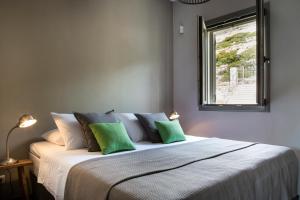 a bedroom with a large bed with green pillows at Myrtos View Apartments in Anomeriá