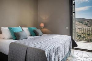 a bedroom with a bed and a large window at Myrtos View Apartments in Anomeriá
