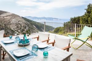a table and chairs on a balcony with a view of the ocean at Myrtos View Apartments in Anomeriá