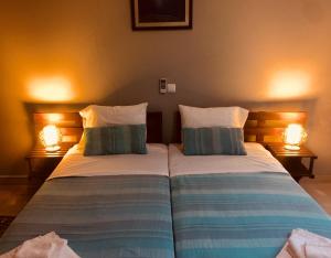 - 2 lits dans une chambre avec 2 lampes dans l'établissement Casa Santa Barbara Deluxe, à Ribeira Grande