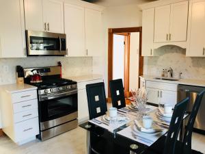 a kitchen with white cabinets and a table with dishes on it at Boston Lodge and Suites in Boston