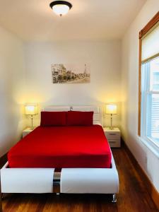 a bedroom with a red bed with two lamps at Boston Lodge and Suites in Boston