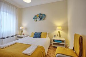 リスボンにあるAlmirante Top Floor / Almirante Reis Avenueのベッドルーム1室(ベッド1台、椅子、窓付)