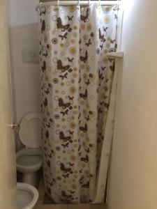 a bathroom with a shower curtain with a toilet at Hotel Loma Alegre in Mar del Plata