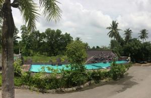 a resort with a swimming pool and palm trees at River Nature Hotel in Suratthani