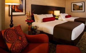 um quarto de hotel com duas camas e uma cadeira em Casino del Sol Resort Tucson em Tucson