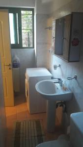 uma casa de banho com um lavatório e um frigorífico em CENTRAL Studio - Fully equiped. Ideal for couples em Patra