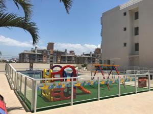 un parque infantil frente a un edificio con parque infantil en Condomínio Estrela do Mar, en Florianópolis