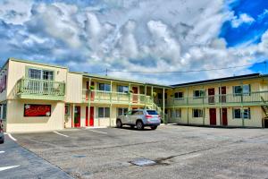 un coche aparcado en un estacionamiento frente a un motel en Sandy Cove Inn, en Seaside