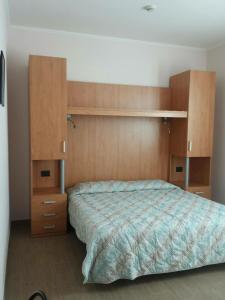 カナーレ・ダーゴルドにあるCasa Alpina Sacro Cuoreのベッドルーム(大型ベッド1台、木製キャビネット付)